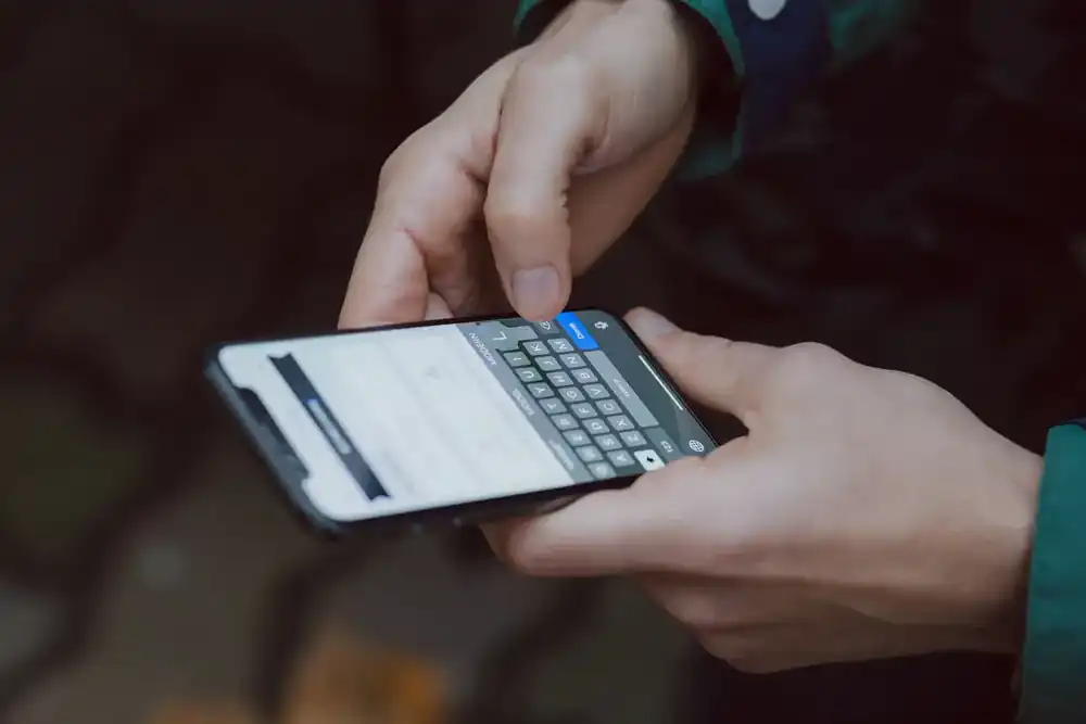Persona escribiendo en un celular para responder mensajes de prospectos interesados en el gimnasio.